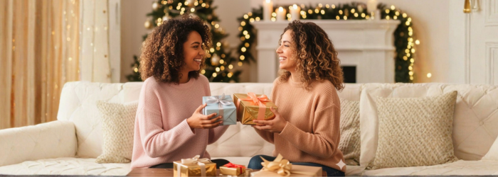 Curly women exchanging gifts